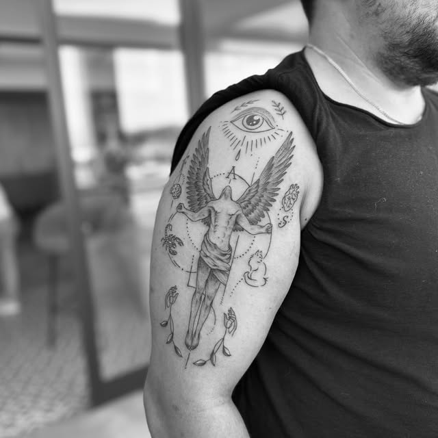 Omuzda kanatlı figür ve göz detaylı illüstratif dövme