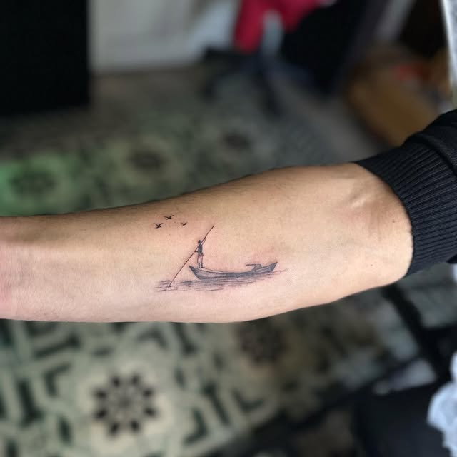 Ön kolda balıkçı ve tekne temalı mikro gerçekçilik dövmesi